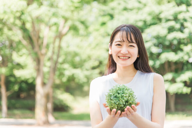 植物を持ちリラックスしている女性