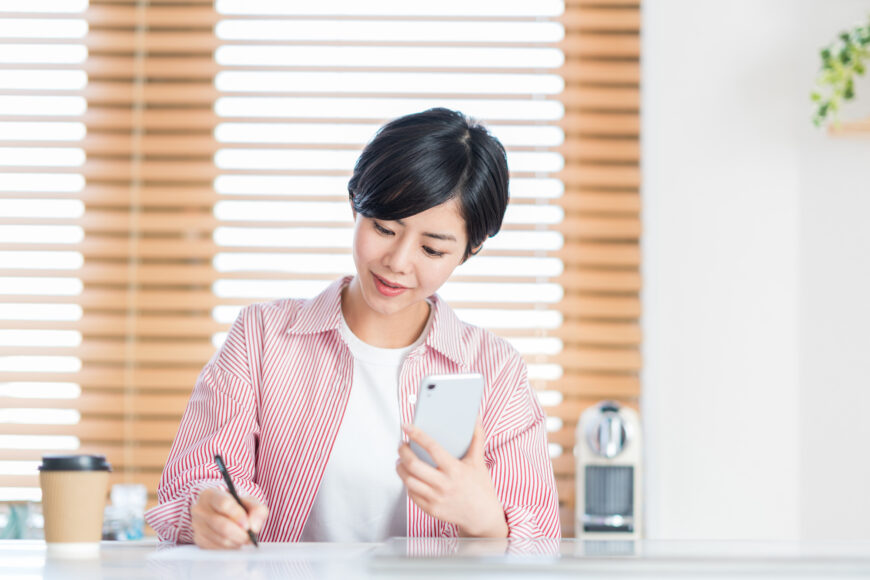 スマホで調べ物をする女性