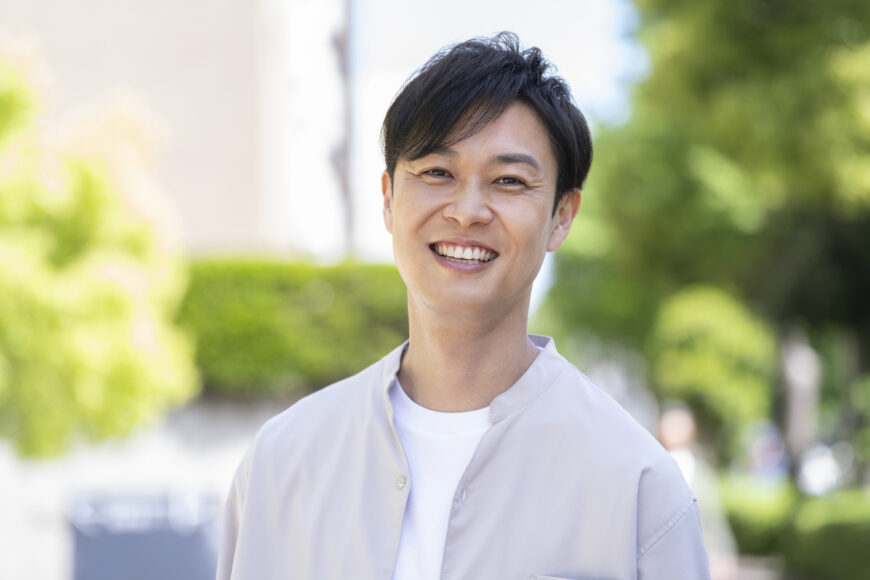 外で微笑む男性